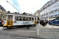 Colorful yellow trams at the Camoes Square in Lisbon