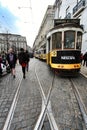 Colorful yellow trams at the Camoes Square in Lisbon