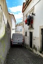 White van passing through narrow street in Alfama