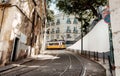 Narrow street with moving tramway on tram rails, past rustic houses in sunny capital city