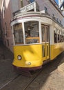 Lisbon, Portugal, October 24, 2021: Close up view of typical yellow vintage tram number 28 line driving down steep Royalty Free Stock Photo