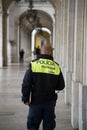 Portrait on back view of portuguese municipal policeman walking in the street