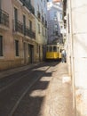 Lisbon, Portugal, October 24, 2021: View of steep narrow Lisbon street with typical yellow vintage tram number 28 line Royalty Free Stock Photo