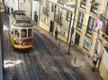 Lisbon, Portugal, October 24, 2021: View of steep narrow Lisbon street with typical yellow vintage tram number 28 line Royalty Free Stock Photo