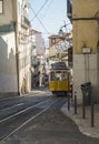 Lisbon, Portugal, October 24, 2021: View of steep narrow Lisbon street with typical yellow vintage tram number 28 line Royalty Free Stock Photo