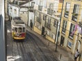 Lisbon, Portugal, October 24, 2021: View of steep narrow Lisbon street with typical yellow vintage tram number 28 line Royalty Free Stock Photo