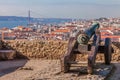 Lisbon, Portugal. Old bronze cannon in Sao Jorge aka Saint George Castle and a view of Lisbon Baixa Distric