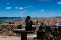 Lisbon, Portugal, rear view of teenage girl sitting alone. Scenic view of the city Royalty Free Stock Photo