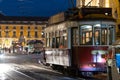 10-29-2022 LISBON, PORTUGAL: red tram with people on the tracks at night