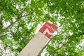 Lisbon subway red identification symbol under green trees background