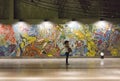 Lisbon subway station with murals and a girl