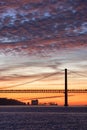 Lisbon 25th of April Bridge at sunset and industrial cranes at the background