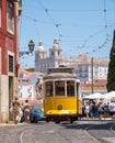 A Lisbon tram carrying passengers in the city with St. Vincent Church in the background Royalty Free Stock Photo