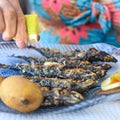 A diner squeezes lemon juice onto freshly grilled Sardines. Lisbon, Portugal