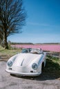 Lisse Netherlands ,. couple doing a road trip with a old vintage sport car White Porsche 356 Speedster, Dutch flower