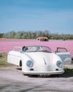 Lisse Netherlands ,. couple doing a road trip with a old vintage sport car White Porsche 356 Speedster, Dutch flower