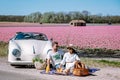 Lisse Netherlands ,. couple doing a road trip with a old vintage sport car White Porsche 356 Speedster, Dutch flower