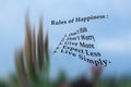 List of happiness rules - Do not hate, do not worry, give more, expect less, live simply. On blurry illustration background of