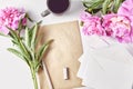 composition of peony flowers, envelopes, sheets of paper and coffee mugs on a white Royalty Free Stock Photo