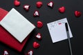 List of top 10 reasons why i love you. Romantic background isolated on black/ Small hearts, silver and red notebook