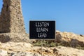 Listen learn lead symbol. Concept word Listen Learn Lead on beautiful black chalk blackboard. Beautiful brown stone blue sky Royalty Free Stock Photo