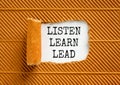 Listen learn lead symbol. Concept word Listen Learn Lead on beautiful white paper. Beautiful brown table brown background. Royalty Free Stock Photo