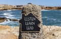 Listen learn lead symbol. Concept word Listen Learn Lead on beautiful black chalk blackboard. Beautiful stone beach sea blue sky Royalty Free Stock Photo