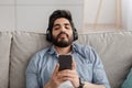 Listen to music with mobile app, watch videos, lesson and learn English online. Young arab guy in wireless headphones Royalty Free Stock Photo