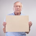 Listen up folks... Studio shot of a senior man holding a blank sign against a grey background. Royalty Free Stock Photo