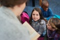 They always listen very attentively when its storytime. a group of elementary school kids listening to their teacher Royalty Free Stock Photo