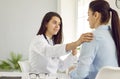 Supportive doctor reassuring young woman during medical consultation at her office