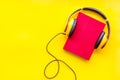 Listening audio books with headphones in library on yellow background top view space for text