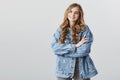 Listening carefully to your point of view. Portrait of pleased grinning charming blonde girl in stylish denim jacket