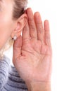 Listening: closeup view of female hand on her ear