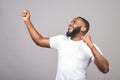 Listening cool music. Young cheerful african american black man moving dancing isolated over grey background Royalty Free Stock Photo