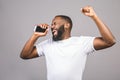 Listening cool music. Young cheerful african american black man moving dancing isolated over grey background Royalty Free Stock Photo