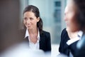 Listening and learning from seasoned coworkers. Attractive businesswoman sitting in a meeting with her coworkers. Royalty Free Stock Photo