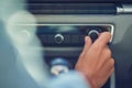 Listening music, cropped shot of a woman turning on radio while driving in the city, close up Royalty Free Stock Photo