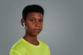 Listening music during workout. Portrait of a teenage african boy wearing wireless earphones looking at camera while Royalty Free Stock Photo