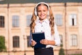Listening school book. Digital technologies for learning. Elearning and modern methods. Girl cute schoolgirl hold book Royalty Free Stock Photo