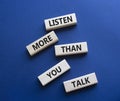 Listening skills symbol. Concept words Listen more than you Talk on wooden blocks. Beautiful deep blue background. Business and Royalty Free Stock Photo