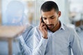 Listening to his clients needs. a handsome young businessman talking on his cellphone in the office. Royalty Free Stock Photo