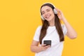 listening to music. influencer blogging. happy girl in headphones on yellow background.