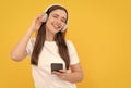 listening to music. influencer blogging. happy girl in headphones on yellow background.