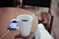 Listening to music on a smartphone while drinking coffee alone in a cafe Royalty Free Stock Photo
