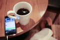 Listening to music on a smartphone while drinking coffee alone in a cafe Royalty Free Stock Photo