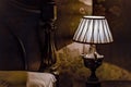 Lit bedside lamp, bedhead and pillow with strong shadows Royalty Free Stock Photo