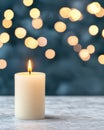 Lit candle with blurred bokeh lights background on a concrete surface. Concept of light and hope for all. Royalty Free Stock Photo