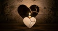 A lit candle casts a large shadow of a broken heart on a textured wall, symbolizing healing and hope Royalty Free Stock Photo