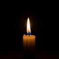 Candle is white and cylindrical, with wax drippings visible. The flame Royalty Free Stock Photo